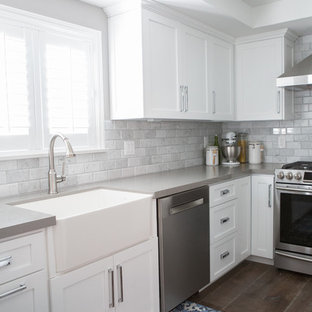 Mid-sized transitional eat-in kitchen photos - Eat-in kitchen - mid-sized transitional u-shaped medium tone wood floor eat-in kitchen idea in Los Angeles with a farmhouse sink, shaker cabinets, white cabinets, quartz countertops, gray backsplash, stone tile backsplash, stainless steel appliances and a peninsula