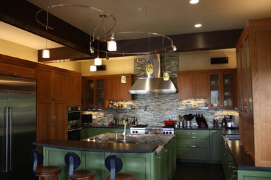 Kitchen - contemporary dark wood floor kitchen idea in San Francisco with a farmhouse sink, green cabinets, granite countertops, multicolored backsplash, glass tile backsplash and stainless steel appliances