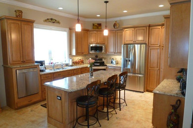 Inspiration for a timeless kitchen remodel in Phoenix with raised-panel cabinets, medium tone wood cabinets, granite countertops and an island