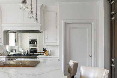 Enclosed kitchen - mid-sized transitional u-shaped enclosed kitchen idea in New York with shaker cabinets, white cabinets, marble countertops, white backsplash, marble backsplash and an island