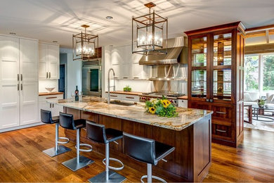 Eat-in kitchen - large contemporary single-wall medium tone wood floor eat-in kitchen idea in Denver with an undermount sink, shaker cabinets, white cabinets, granite countertops, white backsplash, stainless steel appliances and an island