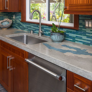 Large tropical eat-in kitchen in Hawaii with an undermount sink, shaker cabinets, medium wood cabinets, concrete benchtops, blue splashback, glass tile splashback, stainless steel appliances, porcelain floors and no island.