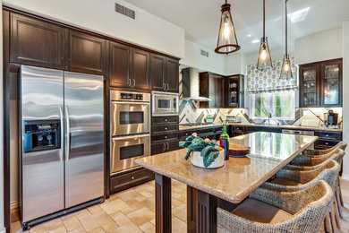 Open concept kitchen - large transitional l-shaped ceramic tile open concept kitchen idea in San Diego with an undermount sink, recessed-panel cabinets, brown cabinets, granite countertops, beige backsplash, porcelain backsplash, stainless steel appliances and an island