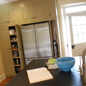 Refrigerator flanked by pantry/broom closet - door to right was once a window.