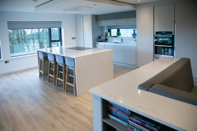Design ideas for a modern open plan kitchen in Other with white splashback, stone slab splashback, an island and white worktops.