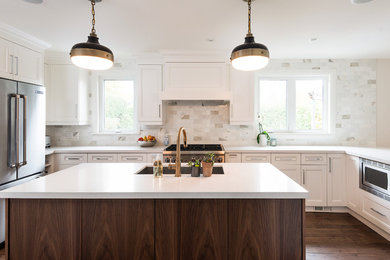 Open concept kitchen - mid-sized contemporary l-shaped medium tone wood floor open concept kitchen idea in Toronto with a single-bowl sink, recessed-panel cabinets, white cabinets, quartzite countertops, white backsplash, stone tile backsplash, stainless steel appliances and an island