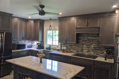 Example of a mid-sized transitional l-shaped porcelain tile and multicolored floor eat-in kitchen design in Providence with a farmhouse sink, flat-panel cabinets, gray cabinets, quartz countertops, multicolored backsplash, mosaic tile backsplash, stainless steel appliances, an island and beige countertops