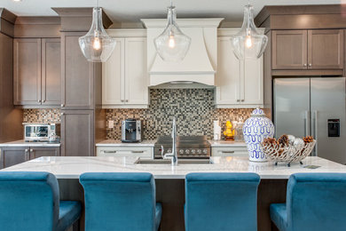 Example of a beach style single-wall kitchen design in Toronto with a farmhouse sink, shaker cabinets, medium tone wood cabinets, multicolored backsplash, mosaic tile backsplash, stainless steel appliances, an island and white countertops