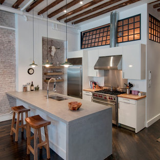 Kitchen - industrial galley kitchen idea in New York with concrete countertops, stainless steel appliances, a double-bowl sink, flat-panel cabinets and white cabinets