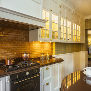 Réalisation d'une cuisine parallèle tradition fermée et de taille moyenne avec un évier 3 bacs, un placard avec porte à panneau encastré, des portes de placard marrons, un plan de travail en granite, une crédence marron, une crédence en carreau de porcelaine, un électroménager encastrable, un sol en carrelage de porcelaine et un îlot central.