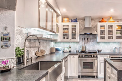 Inspiration for a transitional l-shaped enclosed kitchen remodel in San Diego with a farmhouse sink, shaker cabinets, white cabinets, onyx countertops, multicolored backsplash, ceramic backsplash, stainless steel appliances and an island
