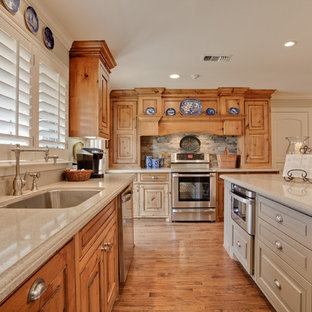 Design ideas for a traditional kitchen in Dallas with an undermount sink, raised-panel cabinets, beige cabinets, stainless steel appliances and slate splashback.
