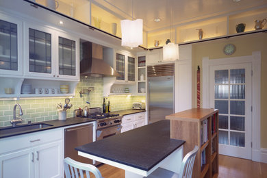 Example of a mid-sized trendy l-shaped medium tone wood floor and brown floor enclosed kitchen design in San Francisco with an undermount sink, shaker cabinets, white cabinets, soapstone countertops, green backsplash, ceramic backsplash, stainless steel appliances, an island and gray countertops