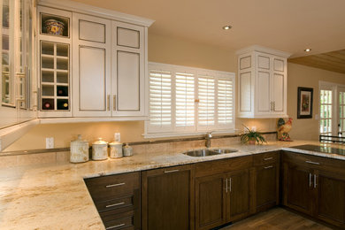 Example of a large transitional u-shaped light wood floor eat-in kitchen design in Albuquerque with a drop-in sink, recessed-panel cabinets, stainless steel appliances and no island