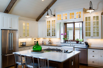 Inspiration for a mid-sized cottage l-shaped dark wood floor and brown floor open concept kitchen remodel in Atlanta with glass-front cabinets, white cabinets, stainless steel appliances, white backsplash, subway tile backsplash, an island, a farmhouse sink and marble countertops