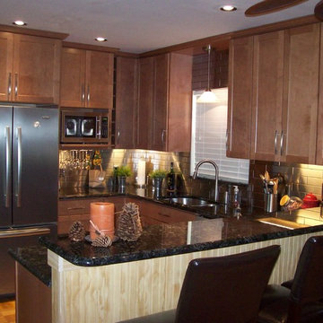 Remodeled kitchen with stainless steel backsplash and maple spice cabinets