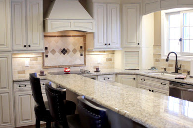Inspiration for a large transitional u-shaped eat-in kitchen remodel in New York with a drop-in sink, raised-panel cabinets, white cabinets, granite countertops, beige backsplash, mosaic tile backsplash, black appliances and an island