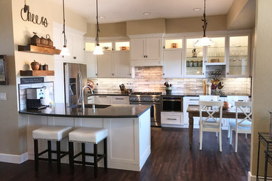 Inspiration for a mid-sized transitional u-shaped dark wood floor and brown floor eat-in kitchen remodel in Other with an undermount sink, recessed-panel cabinets, white cabinets, quartz countertops, gray backsplash, stone tile backsplash, stainless steel appliances, a peninsula and black countertops