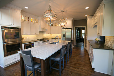 Eat-in kitchen - large contemporary u-shaped dark wood floor and brown floor eat-in kitchen idea in Kansas City with an undermount sink, shaker cabinets, white cabinets, soapstone countertops, gray backsplash, subway tile backsplash, stainless steel appliances and an island