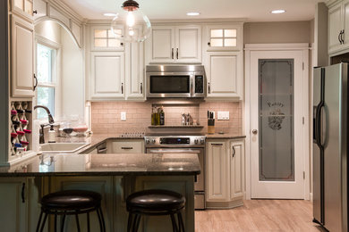 Eat-in kitchen - mid-sized traditional u-shaped light wood floor and beige floor eat-in kitchen idea in Portland with a drop-in sink, raised-panel cabinets, granite countertops, beige backsplash, ceramic backsplash, stainless steel appliances, gray cabinets and a peninsula