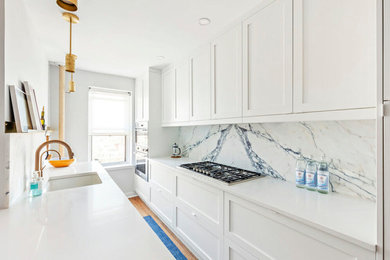 Medium sized traditional galley kitchen pantry in New York with shaker cabinets, white cabinets and a breakfast bar.