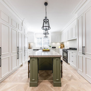 Transitional u-shaped separate kitchen in Sydney with recessed-panel cabinets, white cabinets, white splashback, subway tile splashback, stainless steel appliances, light hardwood floors, with island, beige floor and white benchtop.