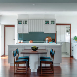 Large transitional l-shaped eat-in kitchen in Perth with an undermount sink, shaker cabinets, grey cabinets, solid surface benchtops, grey splashback, glass sheet splashback, black appliances, dark hardwood floors, with island, brown floor and multi-coloured benchtop.