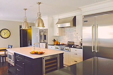 Design ideas for a large classic open plan kitchen in Montreal with a double-bowl sink, shaker cabinets, white cabinets, engineered stone countertops, white splashback, matchstick tiled splashback, stainless steel appliances, dark hardwood flooring and multiple islands.