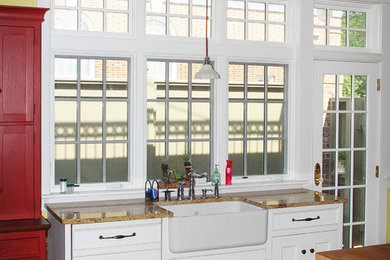 Example of a large classic u-shaped eat-in kitchen design in Philadelphia with a farmhouse sink, recessed-panel cabinets, red cabinets, stainless steel appliances and an island