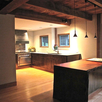 Example of a large mountain style l-shaped medium tone wood floor eat-in kitchen design in New York with a single-bowl sink, flat-panel cabinets, granite countertops, an island, stainless steel appliances and white cabinets