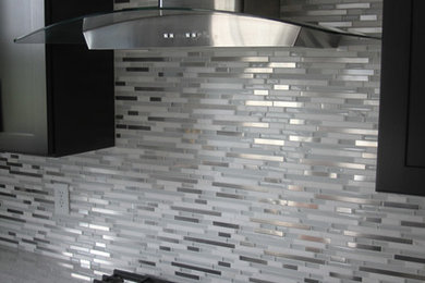Foto på ett funkis kök, med grått stänkskydd och stänkskydd i glaskakel