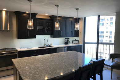Photo of a medium sized traditional l-shaped kitchen/diner in Miami with a submerged sink, white splashback, stainless steel appliances and an island.