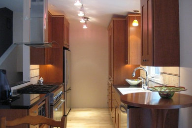 Eat-in kitchen - small modern galley light wood floor eat-in kitchen idea in Other with a drop-in sink, recessed-panel cabinets, medium tone wood cabinets and no island