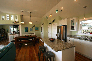 Photo of a medium sized traditional l-shaped open plan kitchen in Other with a double-bowl sink, beaded cabinets, white cabinets, stainless steel appliances, medium hardwood flooring and an island.