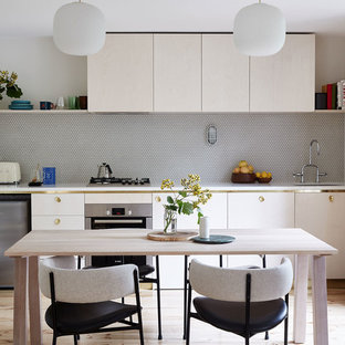 This is an example of a contemporary single-wall eat-in kitchen in Melbourne with an undermount sink, flat-panel cabinets, light wood cabinets, stainless steel appliances, light hardwood floors and no island.