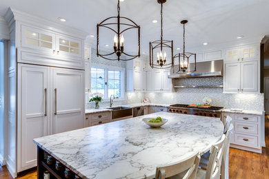 Eat-in kitchen - transitional l-shaped medium tone wood floor eat-in kitchen idea in DC Metro with a farmhouse sink, shaker cabinets, white cabinets, marble countertops, multicolored backsplash, stainless steel appliances and an island