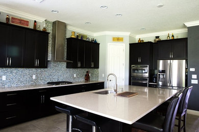 タンパにある広いトラディショナルスタイルのおしゃれなキッチン (アンダーカウンターシンク、シェーカースタイル扉のキャビネット、黒いキャビネット、マルチカラーのキッチンパネル、モザイクタイルのキッチンパネル、シルバーの調理設備、セラミックタイルの床、ベージュの床、白いキッチンカウンター) の写真