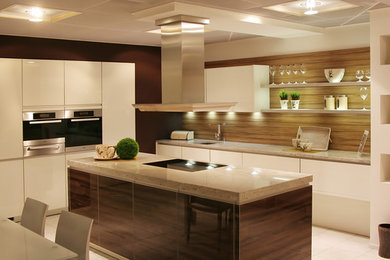 Example of a minimalist eat-in kitchen design in Los Angeles with flat-panel cabinets, white cabinets, quartzite countertops, an island and beige countertops