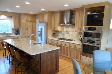 Example of a country l-shaped light wood floor eat-in kitchen design in Other with a single-bowl sink, raised-panel cabinets, light wood cabinets, beige backsplash, stainless steel appliances and an island