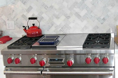ブリッジポートにある広いトランジショナルスタイルのおしゃれなキッチン (白いキッチンパネル、シルバーの調理設備) の写真