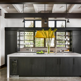 Mid-sized modern open concept kitchen ideas - Example of a mid-sized minimalist concrete floor and gray floor open concept kitchen design in Denver with flat-panel cabinets, black cabinets, quartz countertops, black appliances and an island
