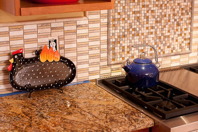 Foto di una piccola cucina minimal con ante lisce, ante in legno scuro, top in granito, paraspruzzi beige, paraspruzzi con piastrelle in ceramica, elettrodomestici in acciaio inossidabile e pavimento in legno massello medio