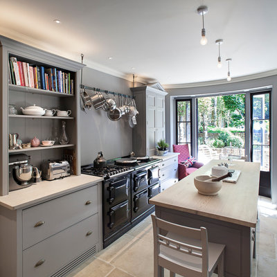 Enclosed kitchen - mid-sized traditional l-shaped enclosed kitchen idea in London with gray cabinets, gray backsplash, ceramic backsplash and an island