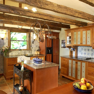 Idee per una cucina rustica con lavello stile country, ante lisce, ante in legno scuro, paraspruzzi multicolore, elettrodomestici da incasso, top in granito e pavimento in terracotta