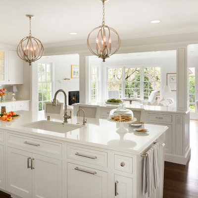 Example of a large classic medium tone wood floor open concept kitchen design in Minneapolis with an undermount sink, shaker cabinets, white cabinets, two islands and white countertops