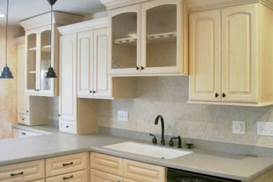 Inspiration for a mid-sized contemporary l-shaped eat-in kitchen remodel in Chicago with an undermount sink, raised-panel cabinets, white cabinets, solid surface countertops, gray backsplash, ceramic backsplash and a peninsula