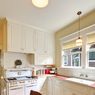 Immagine di una cucina abitabile classica con lavello da incasso, elettrodomestici bianchi, top in laminato, ante bianche, paraspruzzi bianco, ante con bugna sagomata, pavimento multicolore e top rosso