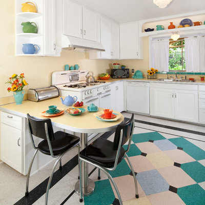 Inspiration for a mid-sized mid-century modern u-shaped linoleum floor and multicolored floor kitchen remodel in Santa Barbara with white cabinets, laminate countertops, white appliances, shaker cabinets, a double-bowl sink, an island and white countertops
