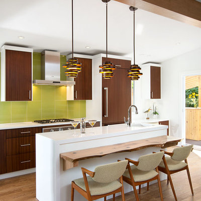 Example of a 1960s single-wall open concept kitchen design in Vancouver with an undermount sink, brown cabinets, quartz countertops, green backsplash and paneled appliances
