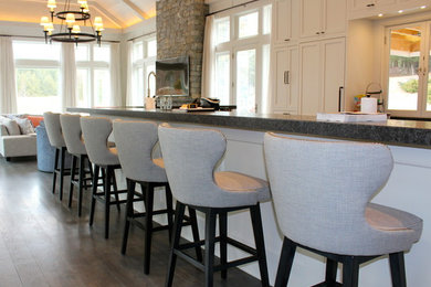 Example of a large transitional single-wall dark wood floor open concept kitchen design in New York with shaker cabinets, white cabinets and an island